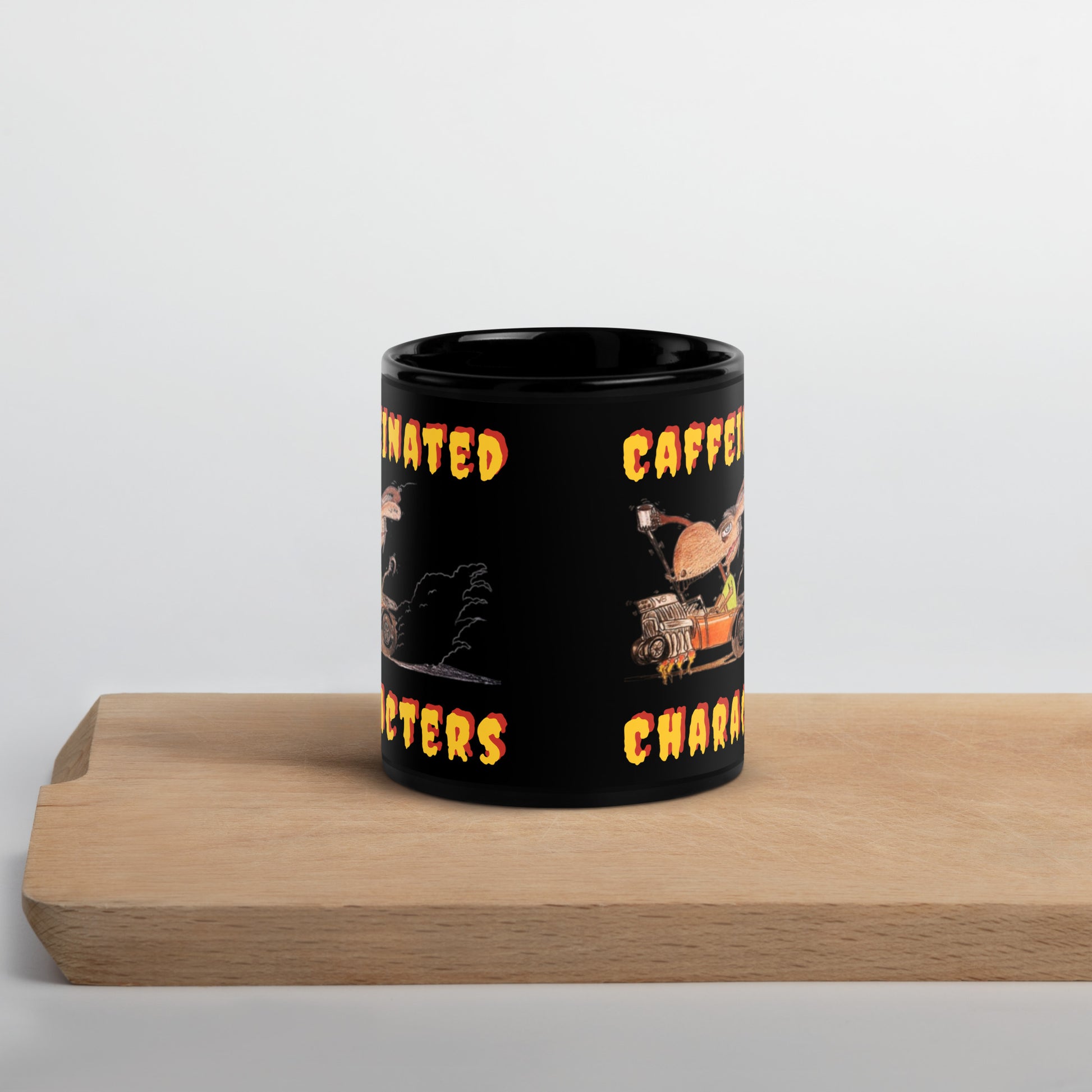 Caffeinated-Character-Yellow-and-Orange-lettering on a black-glossy-mug-11-oz-showing-front-with-no-handle-sitting-on-a-wood-shelf
