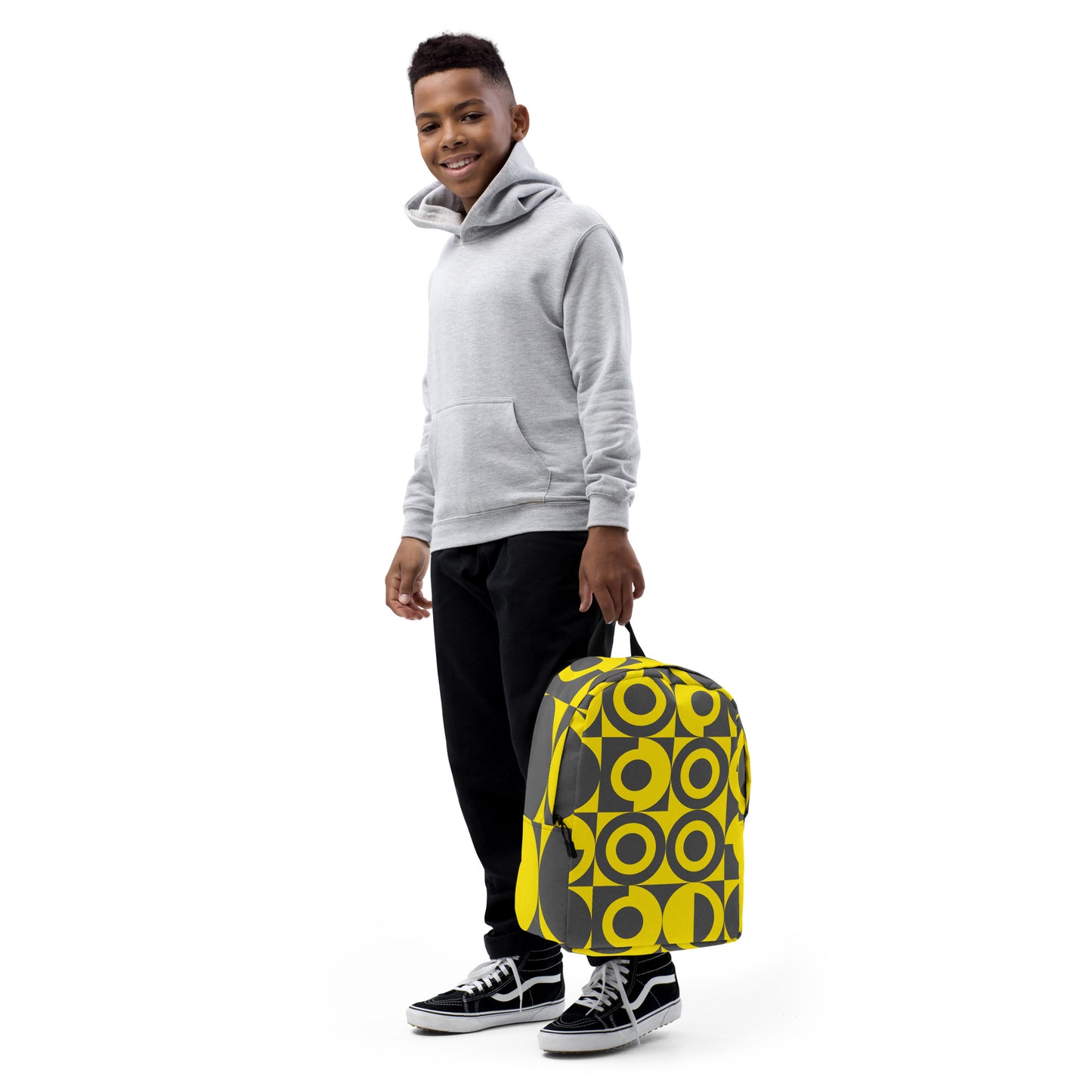 Yellow and Grey Geometric Pattern Backpack, front view with white background and a young boy holding the backpack down by his side with 2 fingers