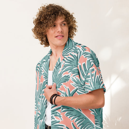 Person wearing a tropical leaf patterned shirt against a plain background