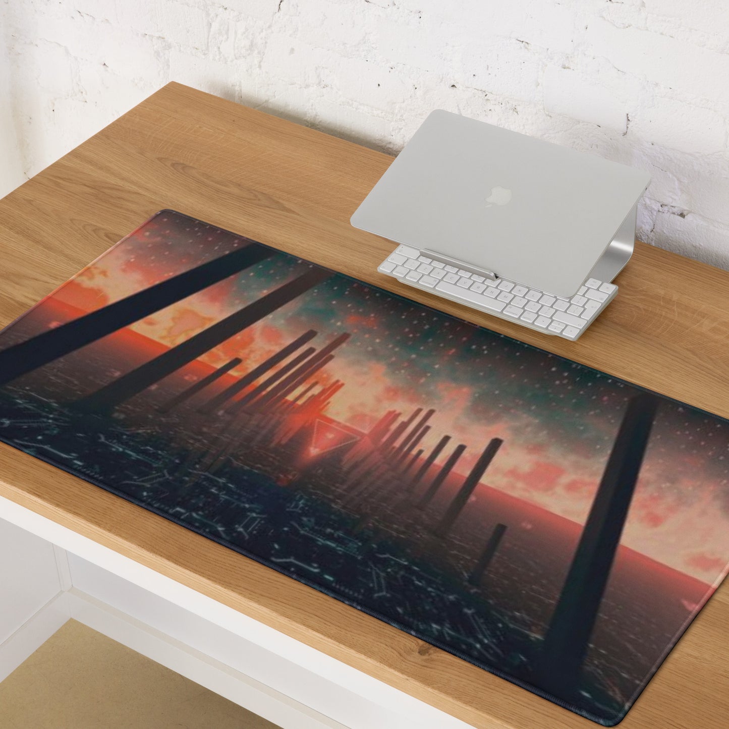 Desk setup with a large desk mat featuring a futuristic design, laptop, and keyboard.