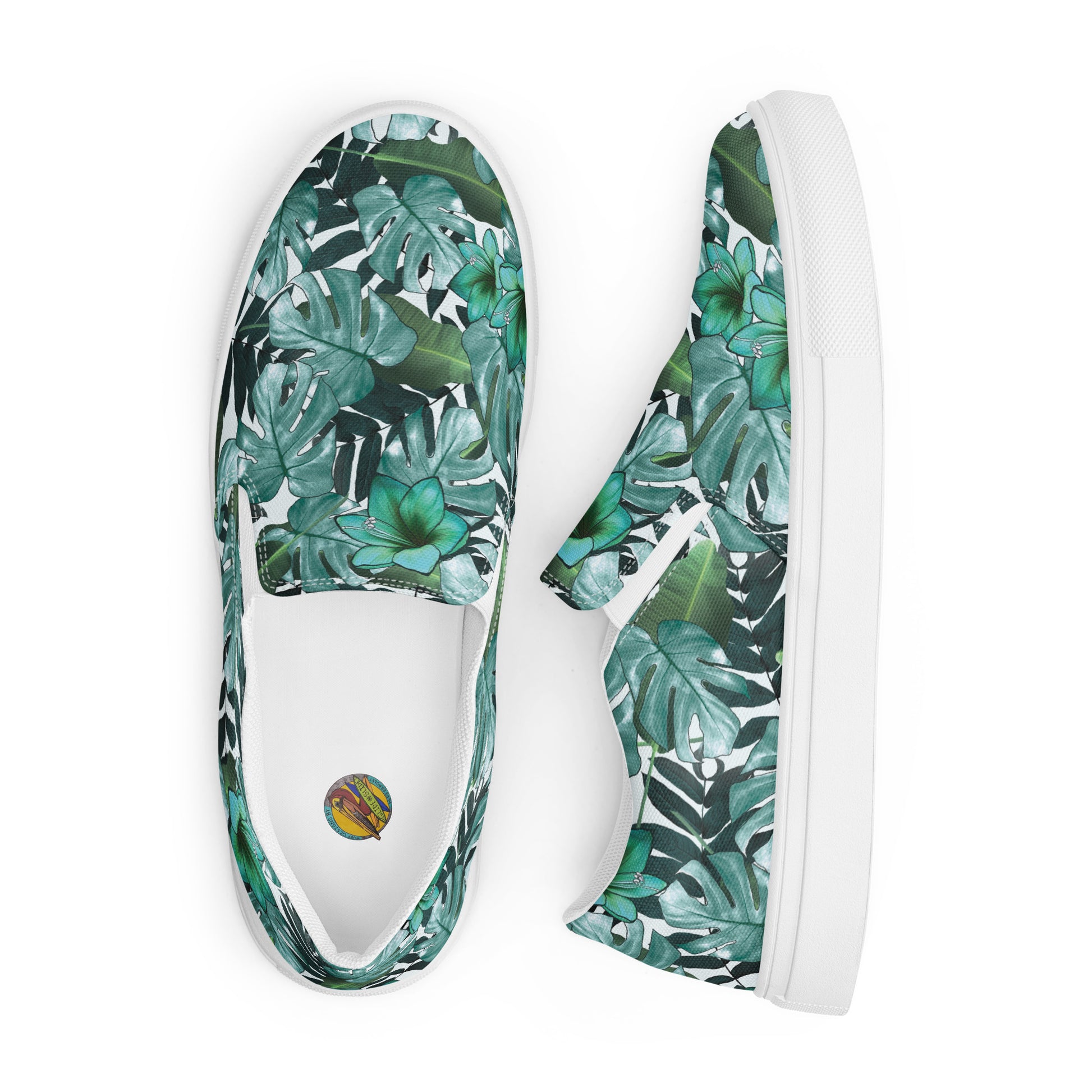 multicolor green tropical print canvas slip on shoes top view showing the Surf Designs by herb Bradley Logo and side view of the other shoe on its side looking down on it