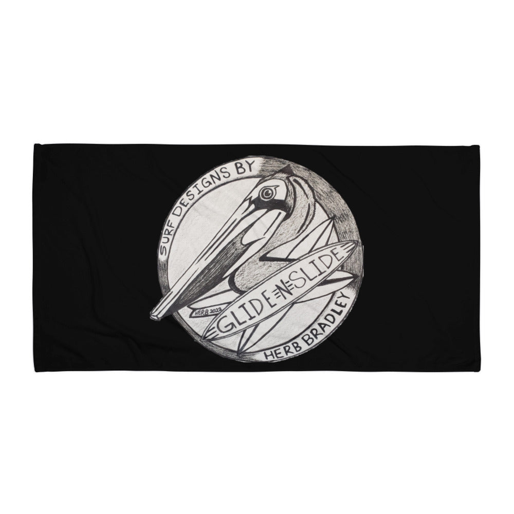 Black Glide -N- Slide Giant Beach Towel with grey and black logo laying flat on the ground