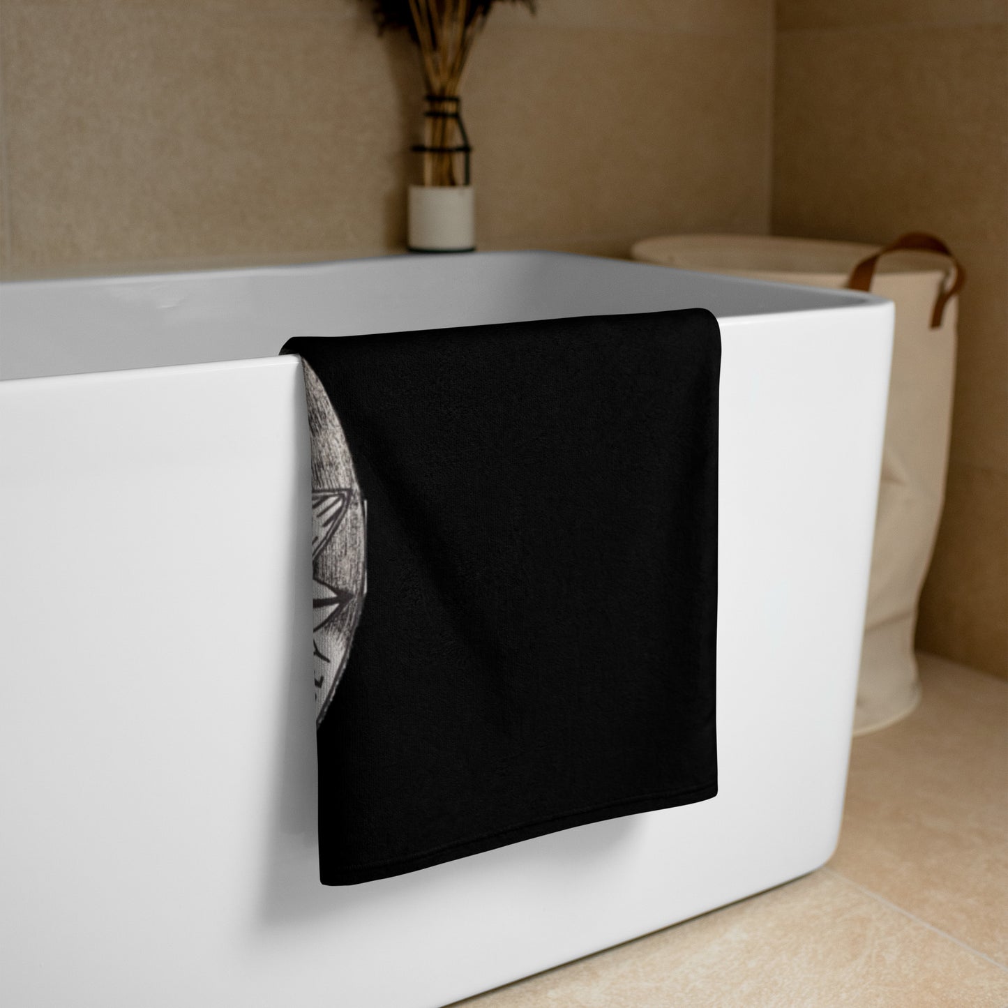 Black Glide -N- Slide Giant Beach Towel with grey and black logo folded over on a bath tun