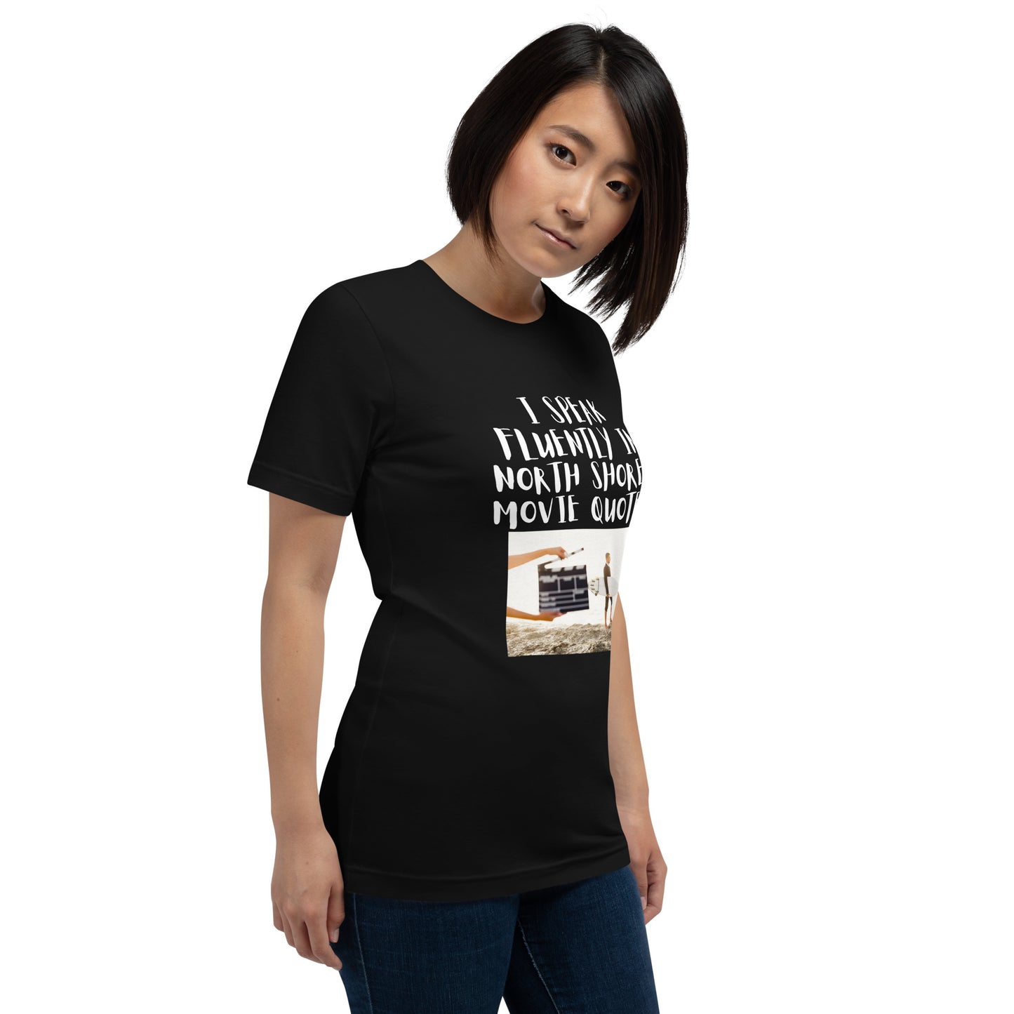 I speak in North Shore Movie Quotes in large text, Picture of a Movie Scene Marker with Surfer holding a surfboard on the beach short sleeve t-shirt in black, side view